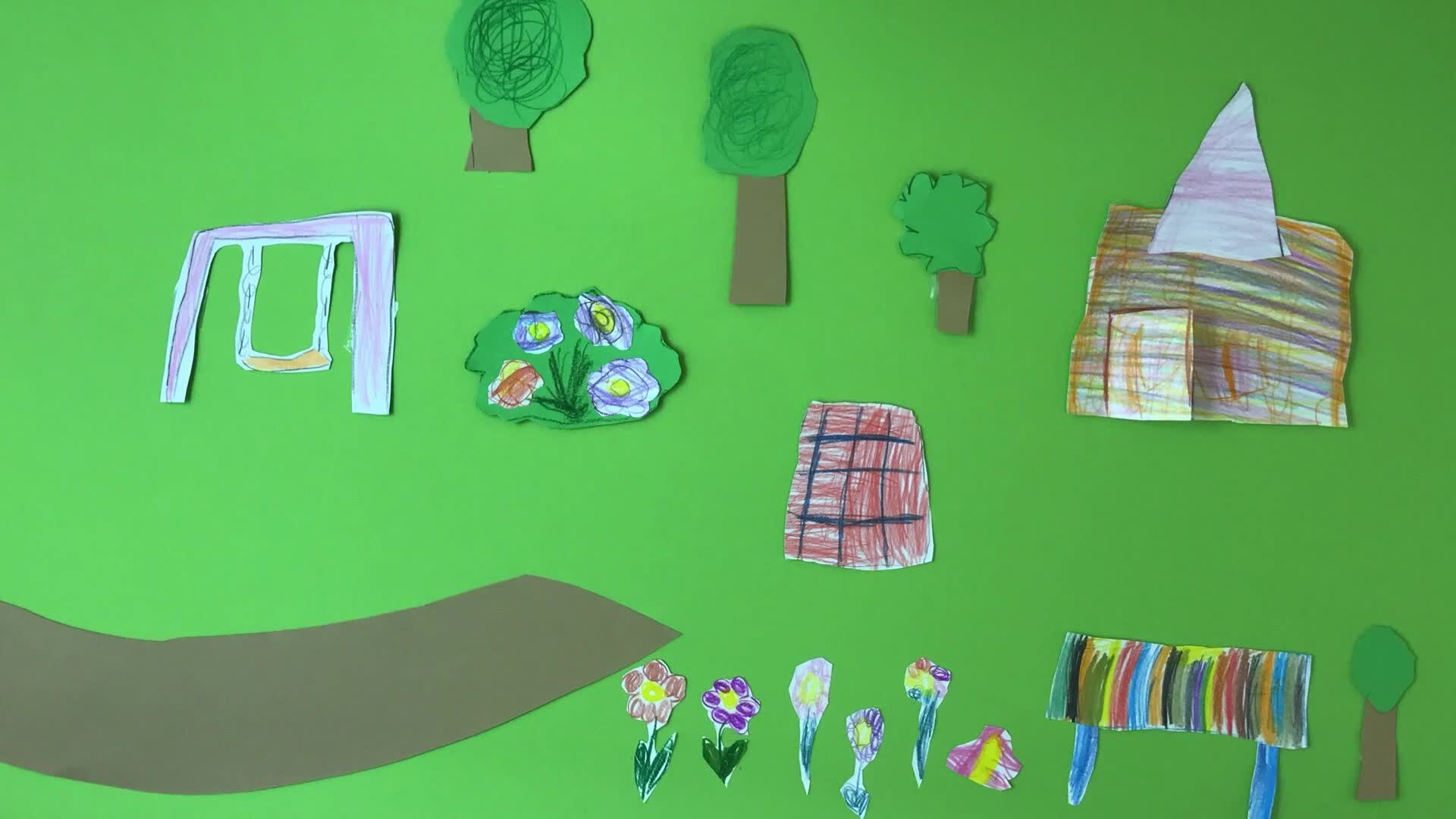 Eine Kindercollage auf grünem Papier zeigt handgezeichnete Ausschnitte von Bäumen, Blumen, einem Weg und einem Haus sowie eine Schaukel und eine Bank, die alle mit farbigem Papier und Buntstiften gezeichnet wurden.